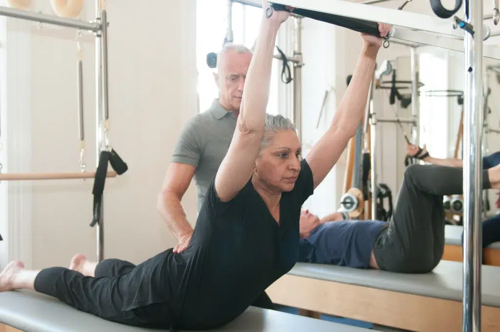 Pilates instructor correcting posture during hypermobility exercise