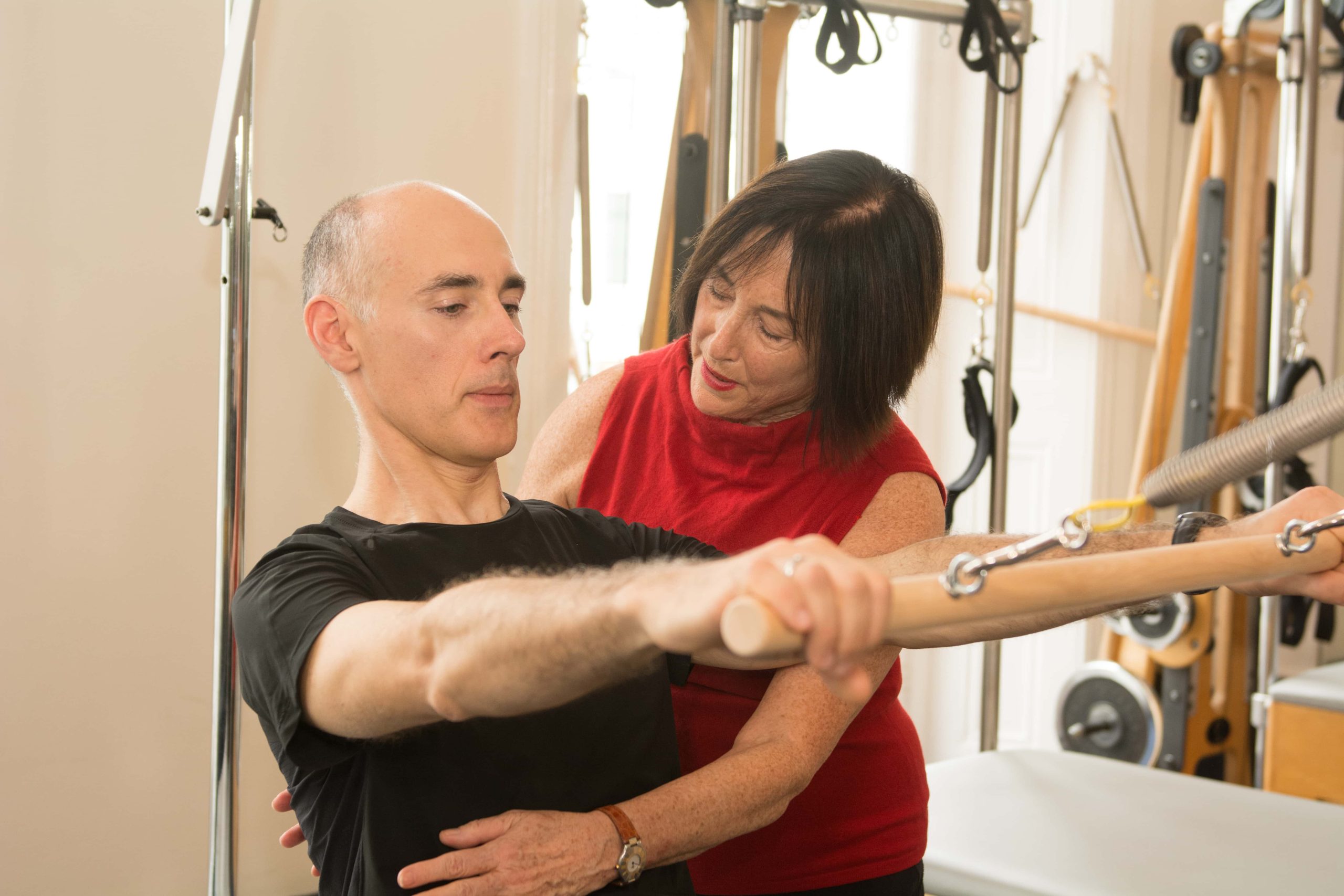 Client in a supported Pilates position on the Reformer, focusing on deep core activation for chronic pain management in London