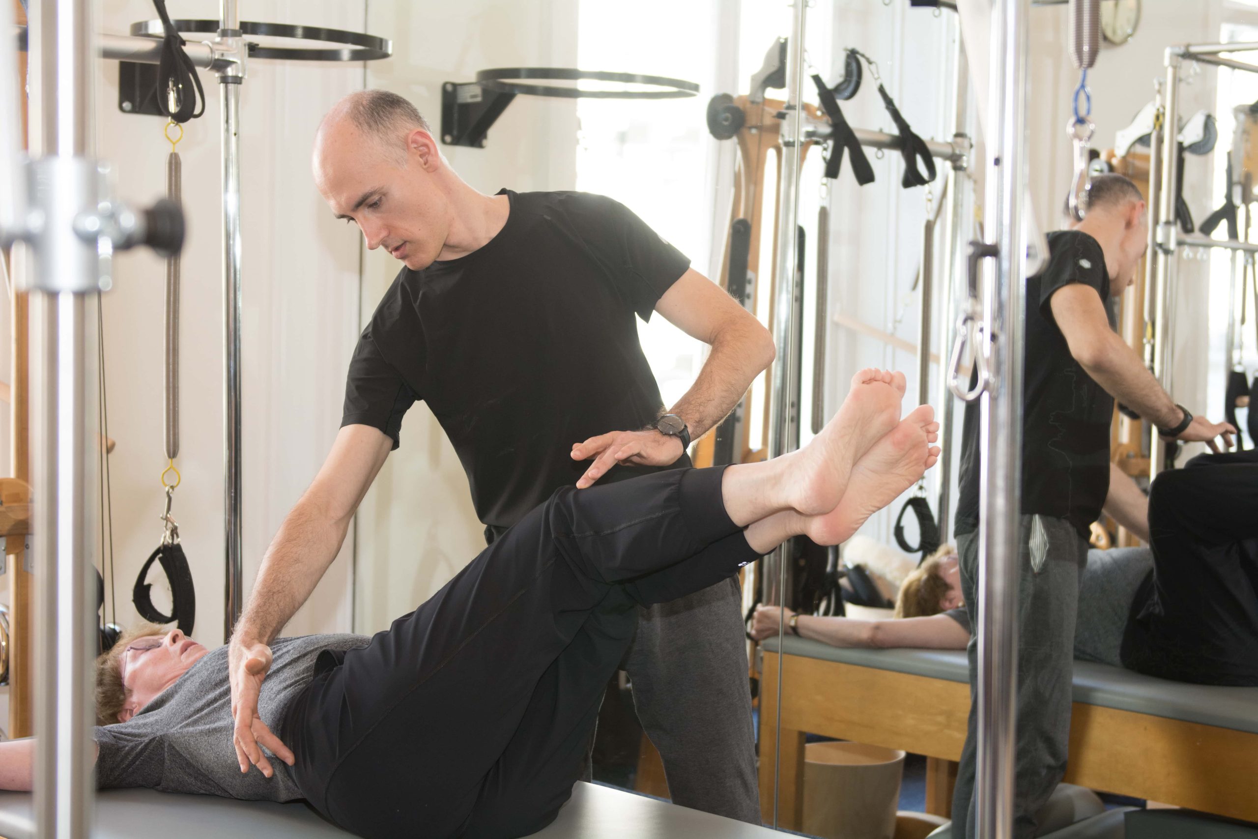 Trevor Blount working one-to-one with a client managing chronic pain on the Cadillac apparatus at the South Kensington studio
