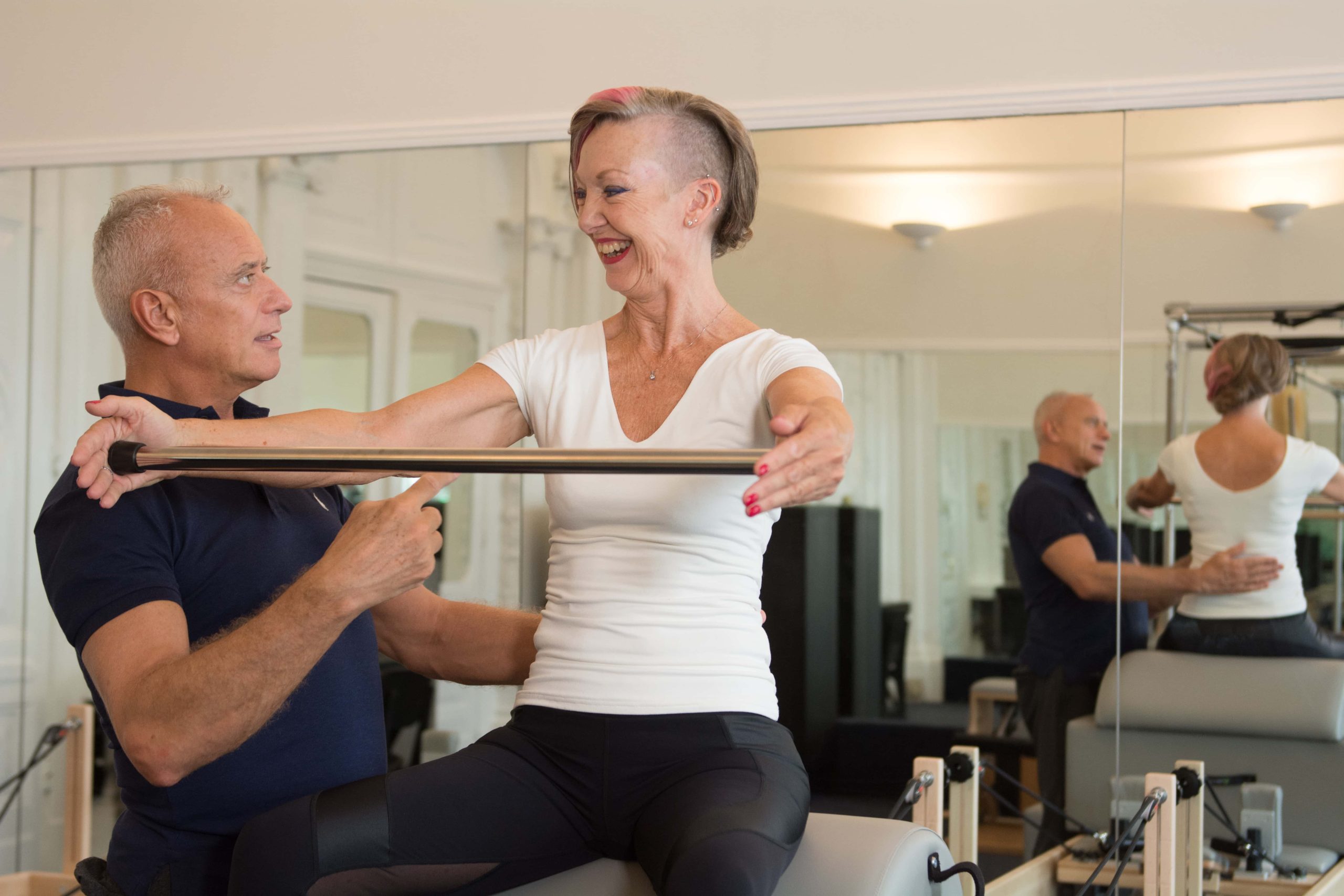 Trevor Blount guiding a client through a one-to-one Pilates session using the Pilates Pole in his South Kensington studio